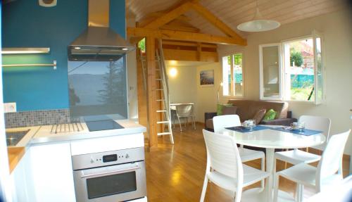 维里尔·杜·拉克Le cottage de Veyrier, très jolie vue Lac - LLA Selections by Location Lac Annecy的厨房以及带桌椅的起居室。