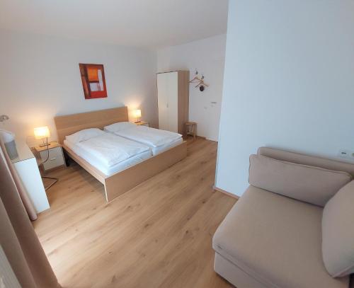BerghausenEwitsch 13 - Hotel Garni的卧室配有白色的床和沙发