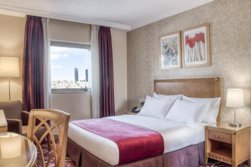 安曼日内瓦酒店的酒店客房设有床和窗户。