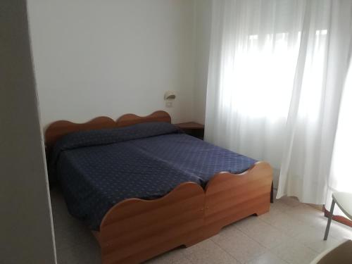 索托马里纳Lorena的一间卧室配有一张带蓝色棉被的床和窗户。