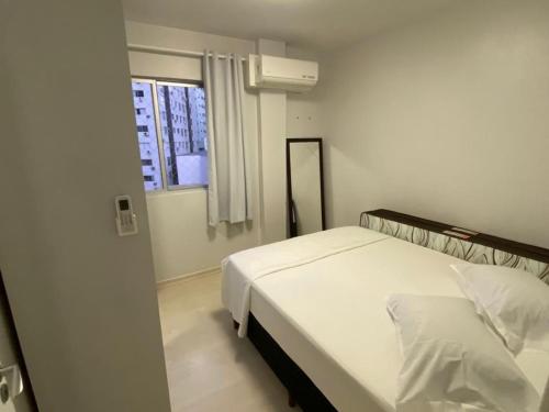 巴拉奈里奥-坎布里乌Quadra do Mar Balneário Camboriú的卧室配有白色的床和窗户。