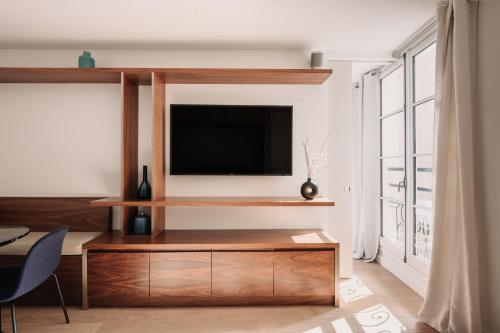 巴黎HIGHSTAY - Luxury Serviced Apartments - Place Vendôme Area的客厅设有壁挂式平面电视。