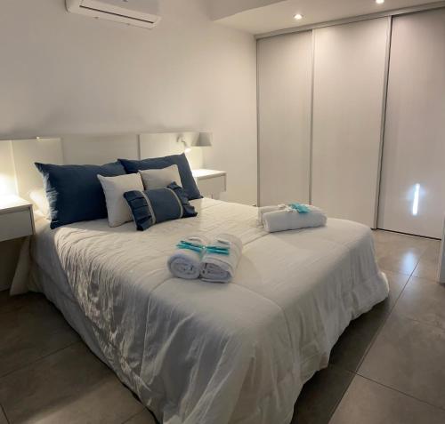 罗萨里奥Suites Quality 2 - Rosario的一间卧室配有一张大床和毛巾