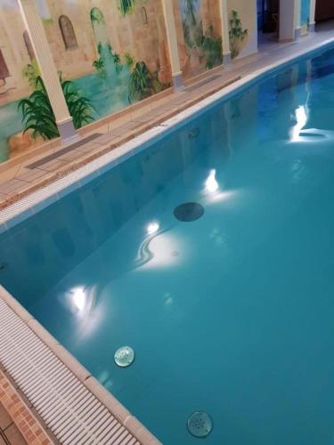 马尔堡Apartament Małgosi的一座大型蓝色游泳池,里面灯光亮丽