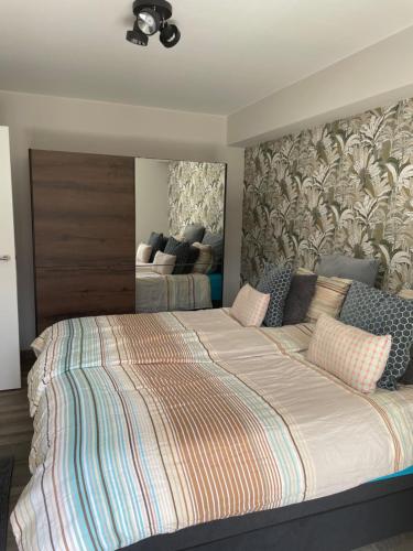 奥斯坦德Fiets & Zee - Bike & Sea的一间卧室配有一张大床和大床头板