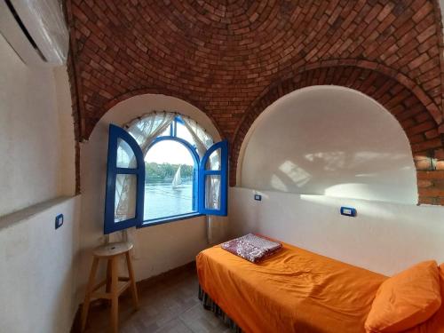 阿斯旺努比安洛特斯住宿加早餐旅馆的一间卧室设有2扇拱形窗户和1张床
