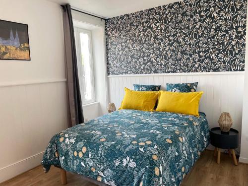 沙托鲁Les Jardins du Château的一间卧室配有一张带蓝色床罩和黄色枕头的床。