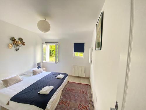 勒帕莱Le coteau的一间白色客房内配有一张大床的卧室