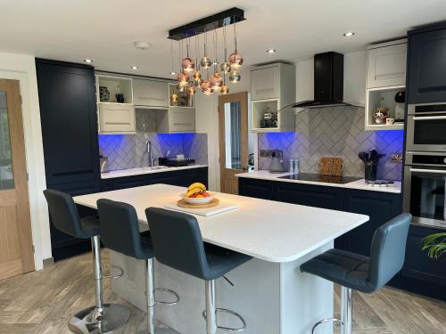 霍利黑德Stylish Modern Home with Parking Enclosed Garden的厨房配有白色桌子和蓝色橱柜