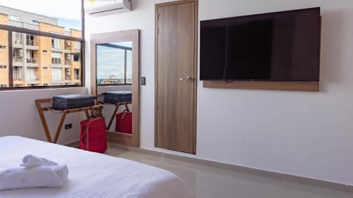 比亚维森西奥Primavera Plus的一间卧室配有一张床和一台平面电视