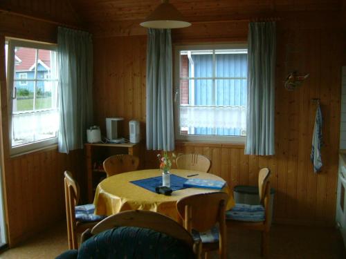 乌塞林Casita的一间带桌椅和2扇窗户的用餐室