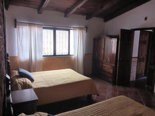 塔帕尔帕Casa Tapalpa的一间卧室设有两张床和窗户。