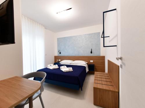 滨海波利尼亚诺Vilu Suite Centro的一间卧室配有一张蓝色的床和一张桌子