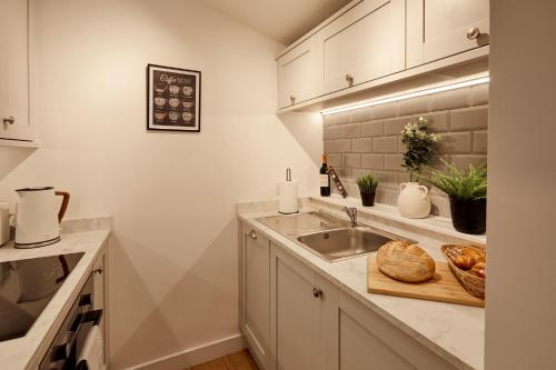 阿伦德尔Norton Studio的厨房配有水槽和带面包的切板