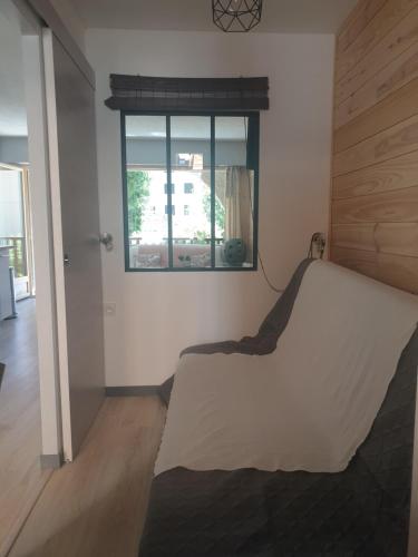 蒙乃第耶-勒潘Magnifique studio, centre, parking privée,terrasse的一间卧室设有一张床和一个窗口