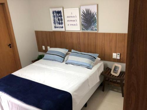 伊塔齐米林Ibiza- Mar& Lazer 3 suítes Itacimirim pé na areia的一间卧室配有一张带蓝色和白色枕头的床
