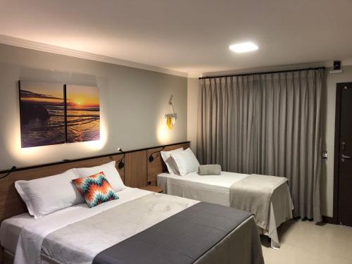 佩尼亚B14 Suítes的酒店客房设有两张床和窗户。