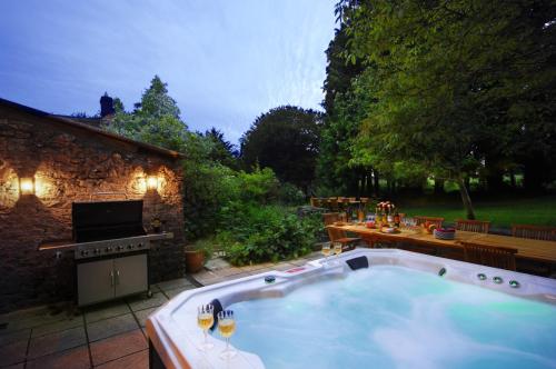 欧克希尔Topside House - Beautiful 7 bedroom house with hottub wifi and parking near Bath Wells Frome的庭院内的大型热水浴池