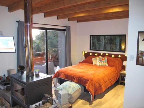 塞拉纳镇Cabaña El Trisquel的一间卧室配有一张带橙色棉被的床