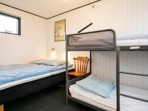 博恩瑟Holiday home Bogense XXXIII的带两张双层床和椅子的房间