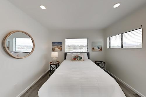 奥希阿诺Barefoot Wishes的白色卧室设有一张大床和镜子