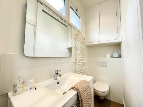 多维尔Appartement Coeur de Deauville的白色的浴室设有水槽和卫生间。