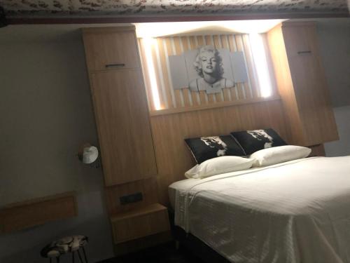 费特希耶Sofya Suites的卧室配有一张带男人照片的床