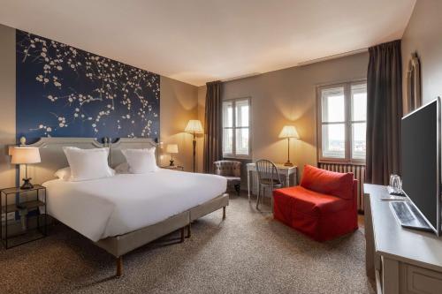 马孔欧洲英格兰德贝斯特韦斯特PLUS酒店的酒店客房,配有一张床和一张红色椅子
