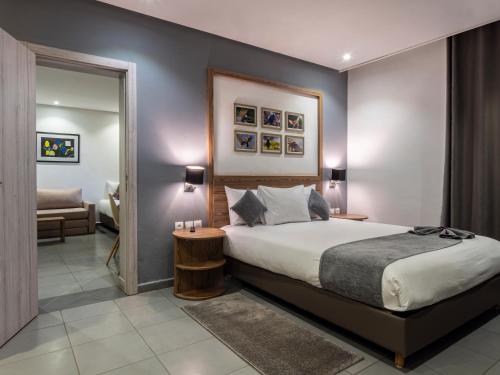 马拉喀什瓦佐公寓酒店 的一间卧室配有一张大床和镜子