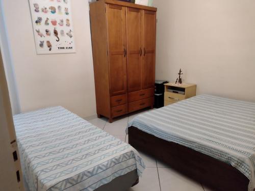 圣维森特岛Praia, sol e lazer的一间卧室设有两张床和木制橱柜