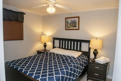 斯诺肖Stroll to Slopes, Village Area, Ski in-out MtLodge 151的一间卧室配有一张床、两盏灯和一个吊扇。