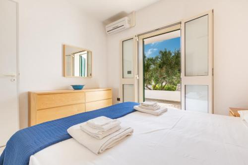 托雷瓦多米拉马尔公寓式酒店的白色卧室,配有带毛巾的床