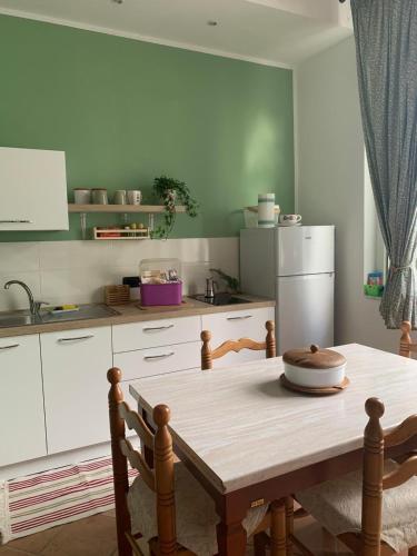 阿谢亚Appartamento Salvia in centro的厨房配有木桌和冰箱。