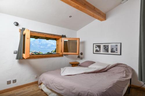圣热尔韦莱班Vielyterra - Chalet haut de gamme - Domaine du mont blanc的一间卧室设有一张床和一个窗口