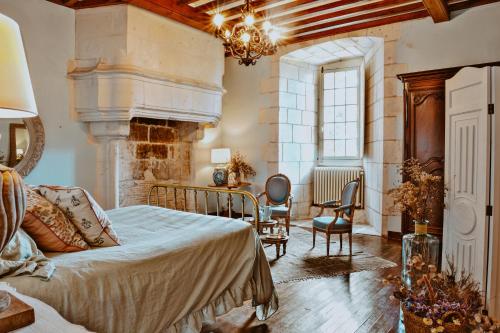 CrazannesChâteau de Crazannes的一间卧室配有一张床和一个壁炉