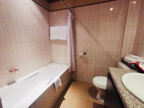 内罗毕La Mada Hotel的带浴缸、卫生间和盥洗盆的浴室