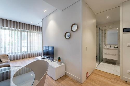 波尔图Antas Park Apartment的客厅配有玻璃桌和电视