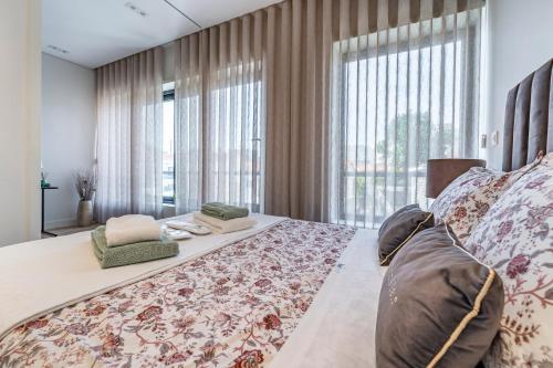 波尔图Antas Park Apartment的一间卧室设有一张大床和大窗户