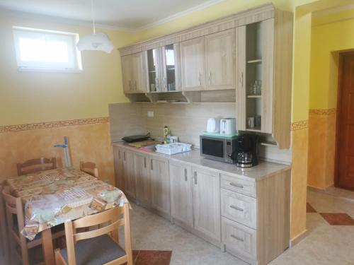豪伊杜索博斯洛Marinica Apartman 3的厨房配有带微波炉的柜台和桌子。