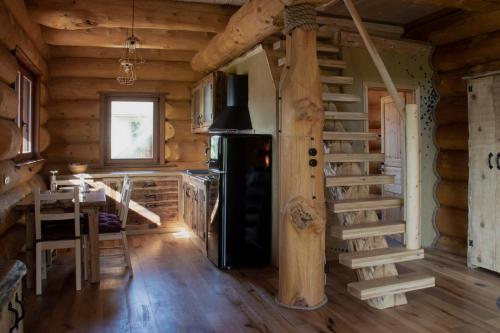 格罗苏普列Brunarica Biopark -Log house Biopark的小木屋内的厨房设有炉灶和楼梯