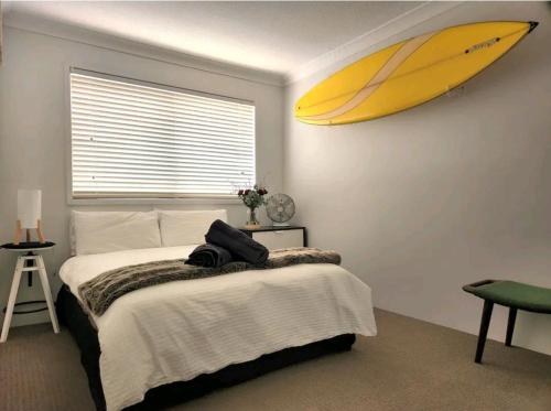 黄金海岸Villas Sienna Homestay的卧室配有挂在墙上的冲浪板