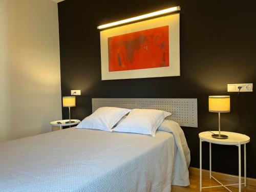 莱昂莱昂公寓的一间卧室配有一张床和两张带台灯的桌子。