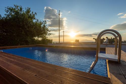 阿纳卡普里Villa Aurora Pool & Fitness的木甲板旁带长凳的游泳池