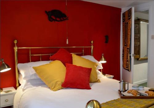 LlangattockCosy holiday cottage in Crickhowell.的一间卧室配有黄色和红色枕头的床