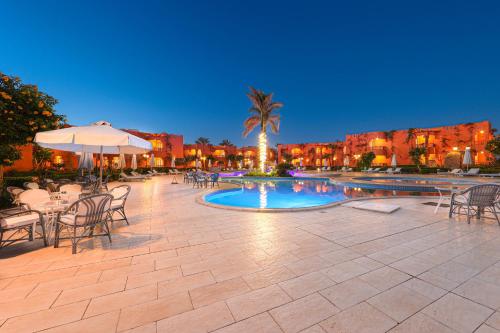 马萨阿拉姆SOULOTEL EMERALD Resort & Spa的一个带桌椅的庭院和一个游泳池