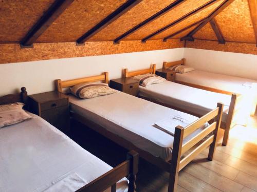 Nova TopolaVikendica Atos的带木天花板的三张床