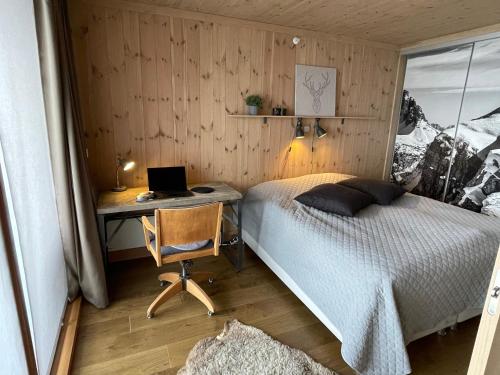 尤坎Gaustatoppen Lodge - Mountain View - Gaustablikk的一间卧室配有一张床和一张带笔记本电脑的书桌
