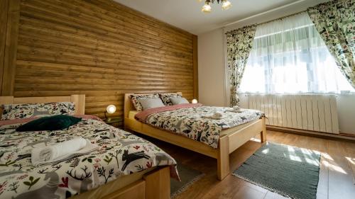 拉夫纳格拉Zimski san的一间卧室设有两张床和木墙