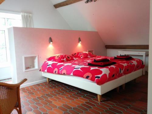 兹瓦尔姆圣布莱修斯霍夫住宿加早餐旅馆的卧室配有红色和白色的床和红色枕头