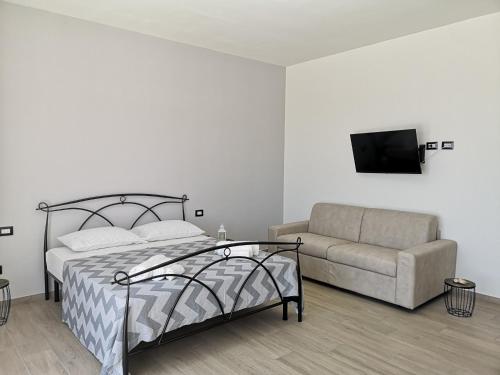 加利波利B&b tra scirocco e tramontana的一间卧室配有一张床和一张沙发